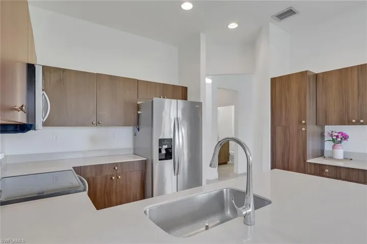 Sleek, modern kitchen with quartz countertops, stainless steel appliances, beautiful wood cabinets, large pantry, ample cabinet/counter space!