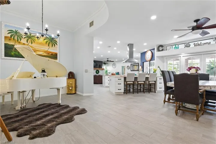 Dining room featuring recessed lighting, crown molding, light wood-style floors, visible vents, and ceiling fan with notable chandelier