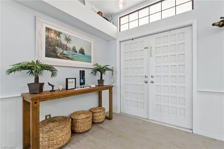 Foyer entrance featuring wood finished floors and a wainscoted wall