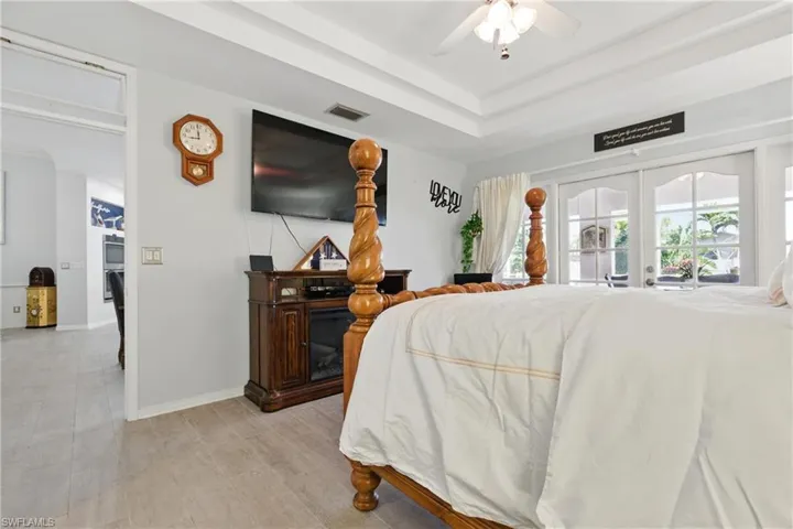 Bedroom featuring access to outside, baseboards, french doors, visible vents, and ceiling fan