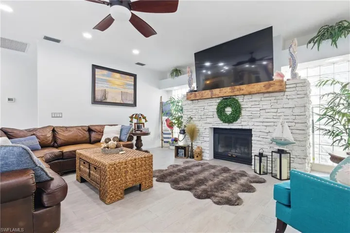 Living area featuring visible vents, ceiling fan, and wood finished floors
