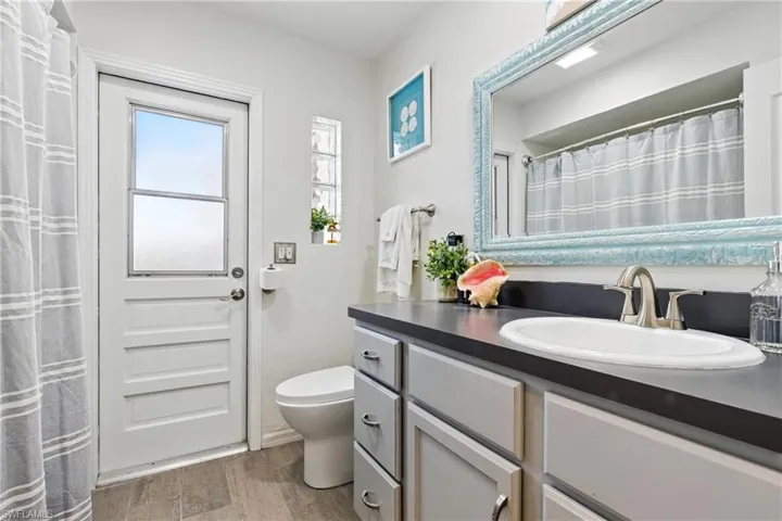 Full bathroom with vanity, toilet, and wood finished floors
