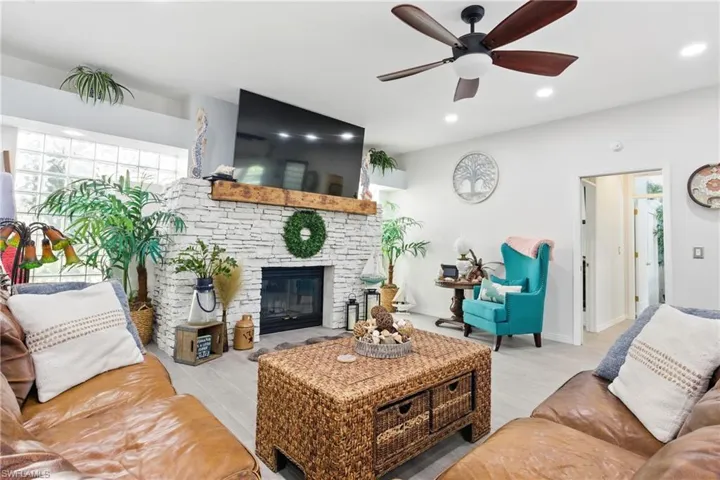 Living room featuring recessed lighting, a fireplace, and ceiling fan
