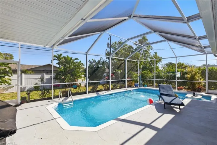 View of swimming pool featuring fence, a fenced in pool, a patio, and a lanai