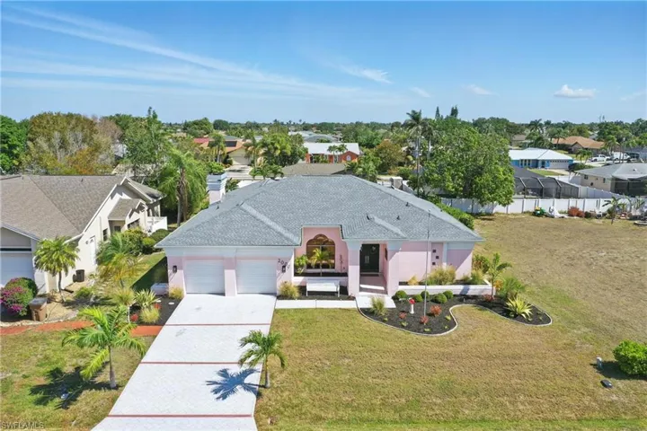 View of front of house with an attached garage, a residential view, driveway, and a front lawn