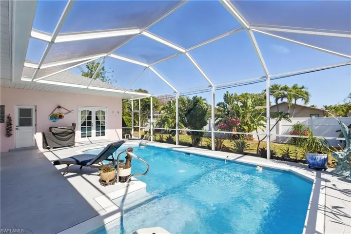 View of pool featuring a fenced in pool, a patio, french doors, glass enclosure, and fence