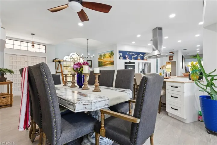 Dining room with crown molding, recessed lighting, and ceiling fan with notable chandelier