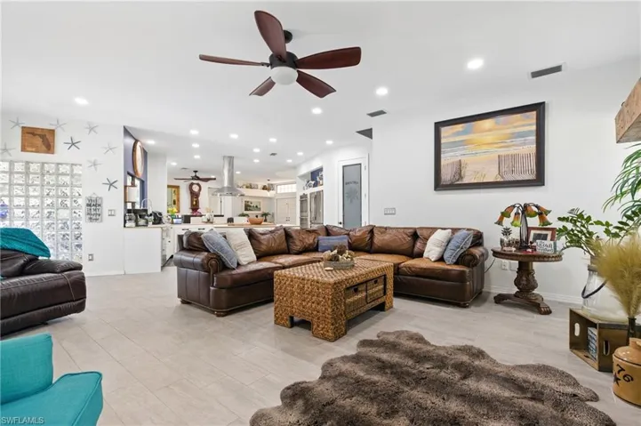 Living room with visible vents, baseboards, a ceiling fan, and recessed lighting