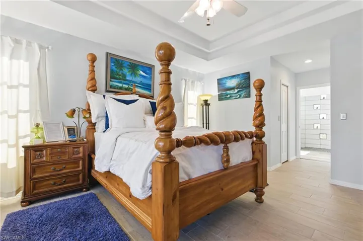 Bedroom with light wood-type flooring, baseboards, a ceiling fan, and recessed lighting