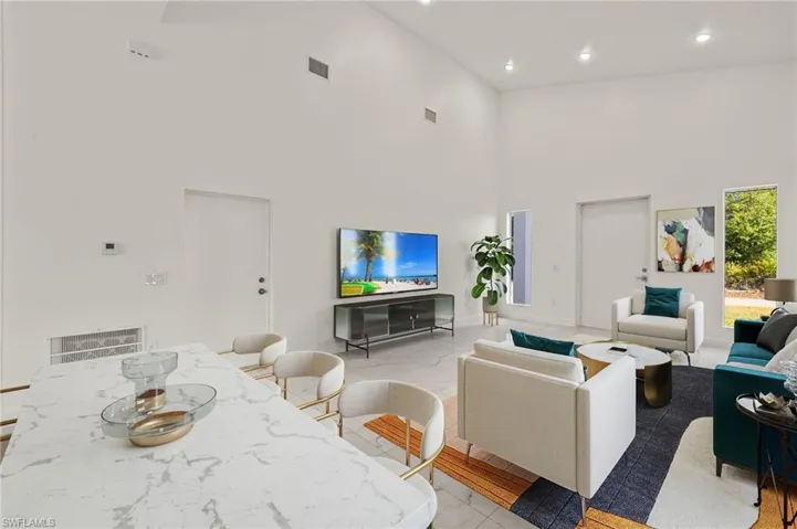 Living area with recessed lighting and a high ceiling