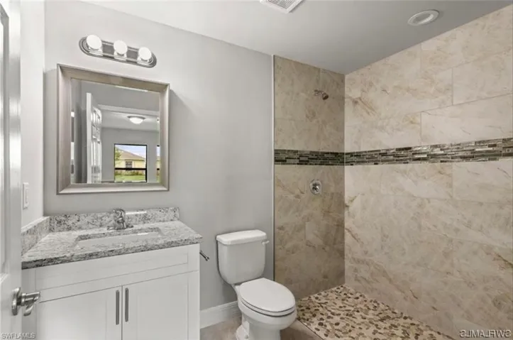 Full bathroom featuring a tile shower and vanity