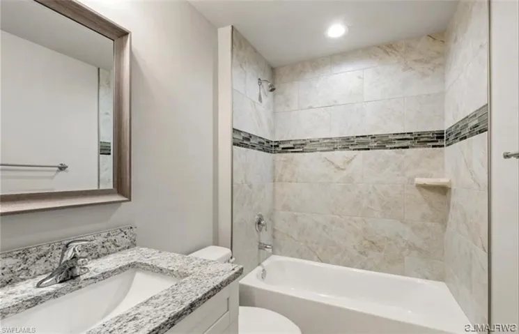 Full bathroom with vanity, shower / bath combination, and recessed lighting