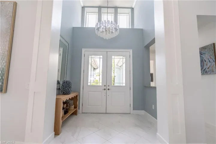 Soaring ceilings with abundent high windows make the entry very bright and cheerful. Beautiful "seaglass" chandelier graces the soaring entry