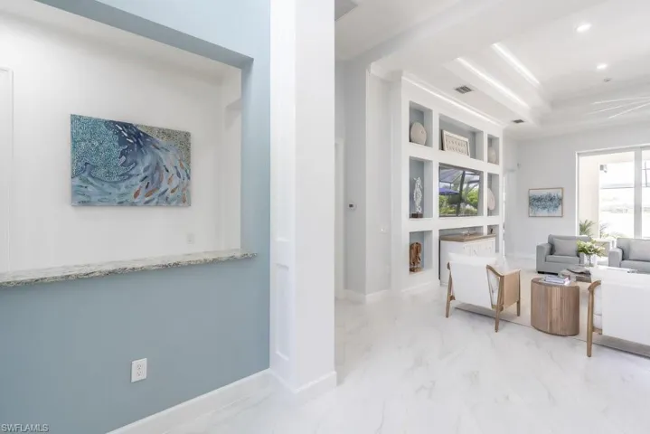 Bright entry foyer with pass through that allows for special artwork to shine through.