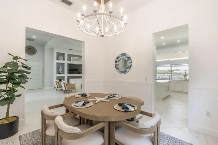 The dining room ceilings are very high and dramatically trayed with inlaid hardwood, providing a warm and classy focal point, graced by a modern white chandelier.