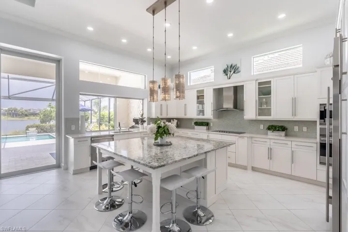 There are great views of the pool, the lanai, and the lake beyond from everywhere in the kitchen. Beautiful glass tile provides the backsplash for the counters. An exceptional modern glass hood graces the cooktop and gives ventilation. with a touch of class.