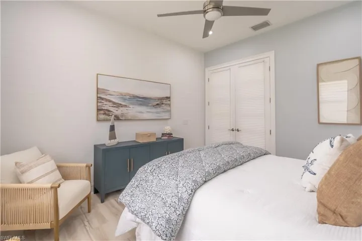 An accent wall of ship lap brings in a subtle coastal vibe. French doors have custom blinds to provide privacy.