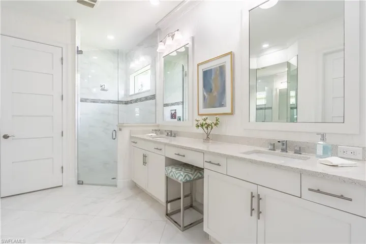 Dual vanities, large mirrors, and a huge amount of counter space allows for a makeup seating area and then some!