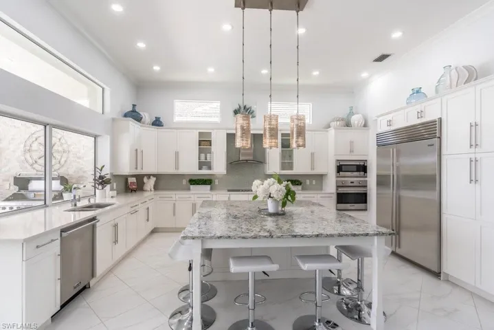 Huge central island seats six, with plenty of room to spare and is anchored by gorgeous pendant lights, chosen by one of Naples dand dollar award-winning designers.