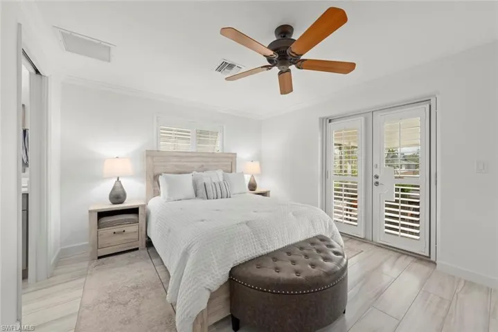 Bedroom with access to exterior, visible vents, crown molding, and baseboards