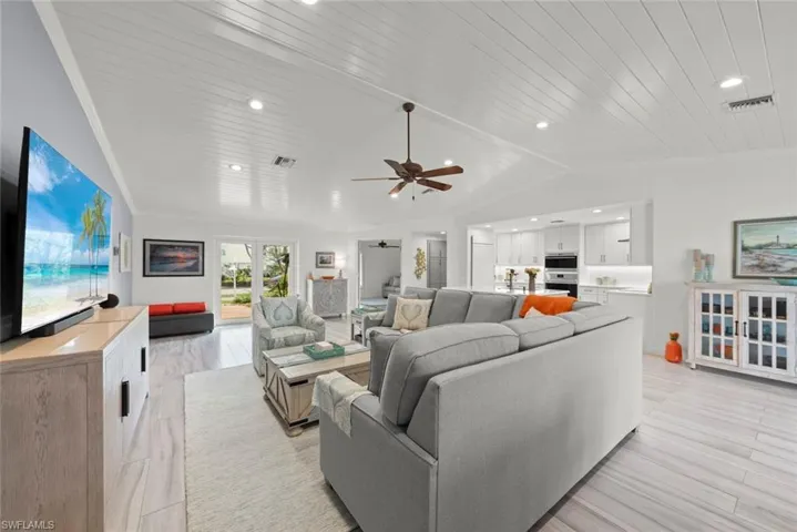 Living area featuring lofted ceiling, wooden ceiling, recessed lighting, visible vents, and crown molding