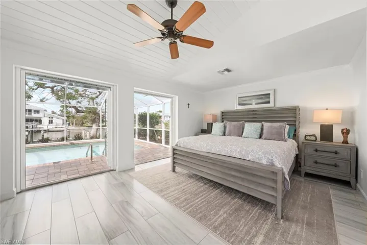 Bedroom with lofted ceiling, a sunroom, visible vents, access to exterior, and crown molding
