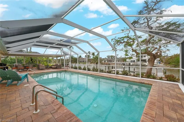 Outdoor pool with a lanai and a patio area