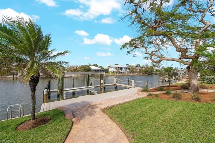 View of dock featuring a yard, a water view, and boat lift