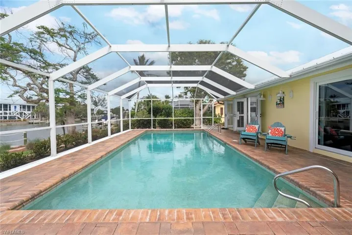 Outdoor pool with a patio and glass enclosure