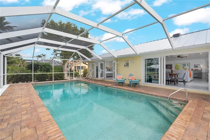 Pool featuring glass enclosure and a patio area