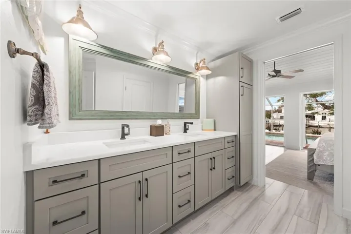 Full bath with double vanity, visible vents, a sink, and ensuite bathroom