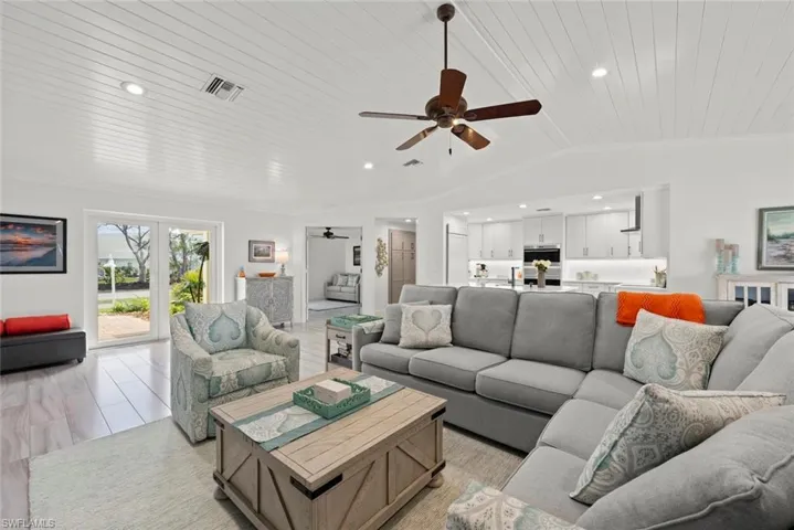 Living area featuring lofted ceiling, wooden ceiling, recessed lighting, visible vents, and crown molding