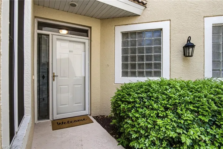 Welcoming entry featuring a white panel front door with sidelights, recessed overhead lighting, and a "Welcome" doormat