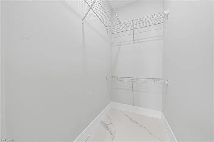 White wire shelving, white walls, and light-toned tile flooring