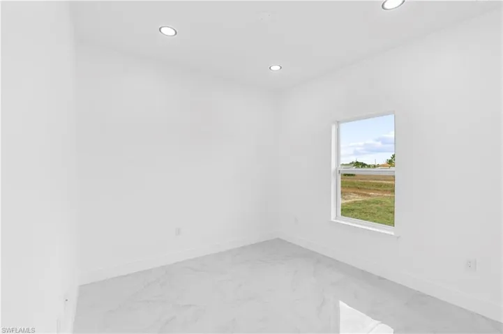 Unfurnished room with light marble finish flooring and recessed lighting