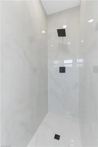 Full bath featuring a marble finish shower