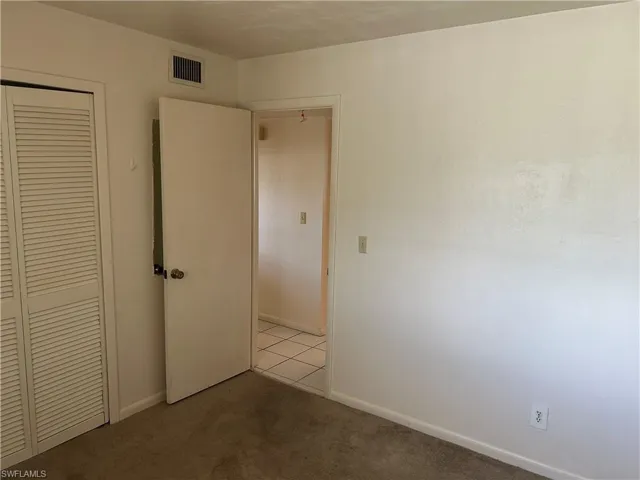 Unfurnished bedroom with a closet and carpet floors