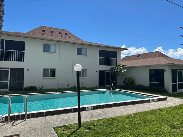 Community pool with a yard, a patio area, and a sunroom