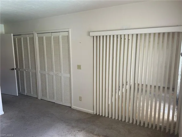 Unfurnished bedroom with multiple closets and carpet flooring