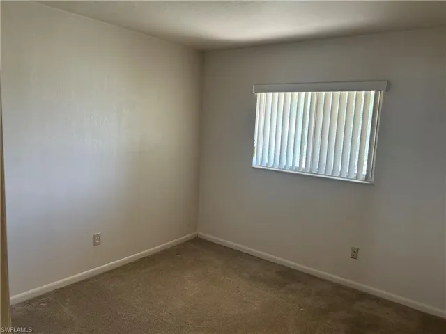 Empty room with carpet flooring and baseboards