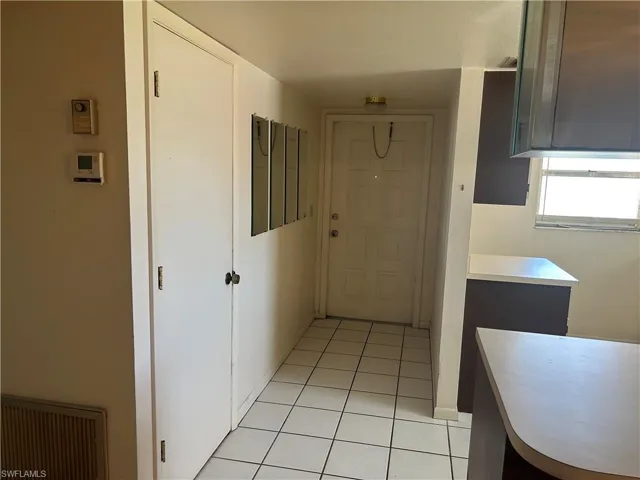 Hallway with light tile patterned flooring and baseboards