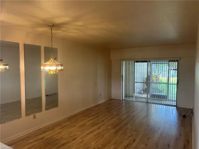 Spare room featuring wood finished floors and baseboards