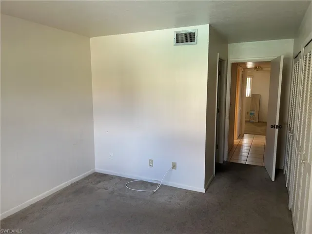 Carpeted empty room with baseboards