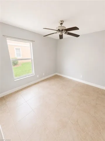 Spacious interior room featuring light neutral wall paint and large format tile flooring