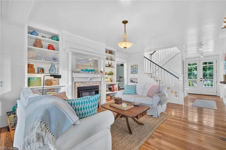 Living room showcases expansive bay views and is anchored by a charming shell-encrusted fireplace