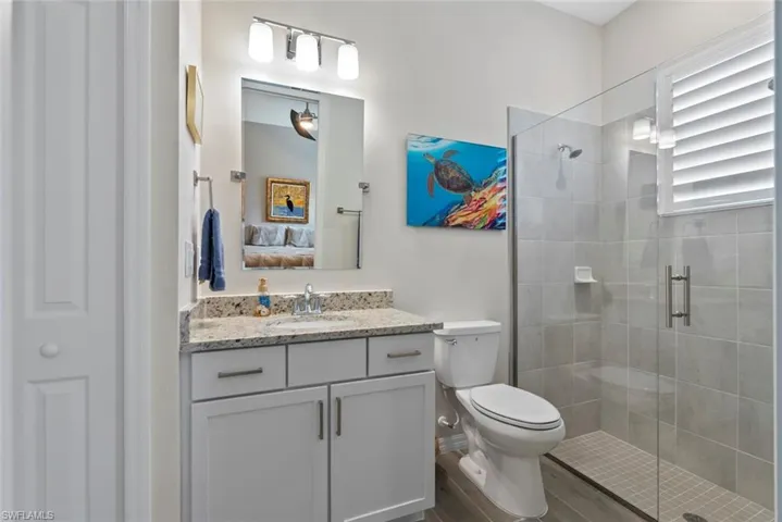 Bathroom with vanity, wood finished floors, toilet, connected bathroom, and a shower stall