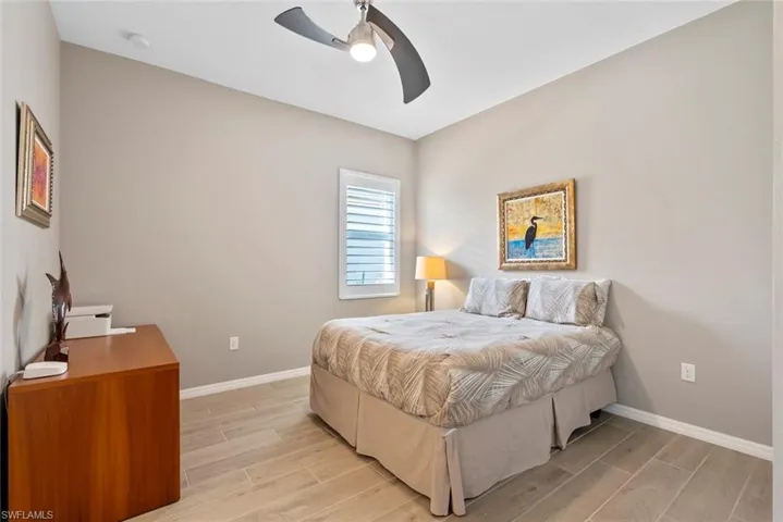Bedroom with baseboards, light wood-style flooring, and ceiling fan