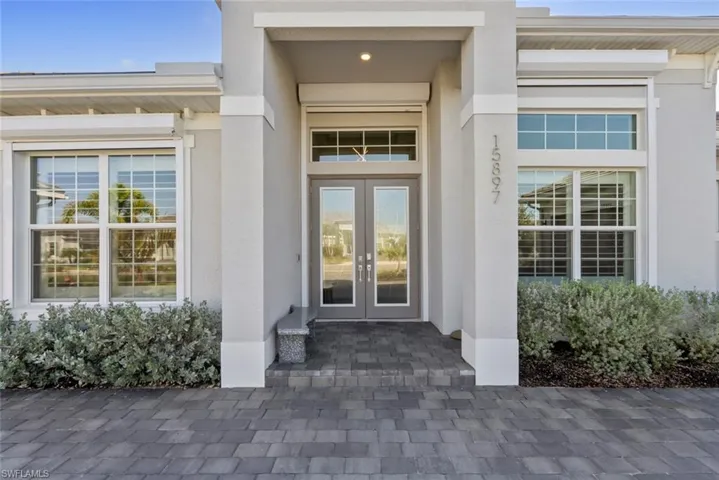 View of exterior entry featuring french doors and stucco siding