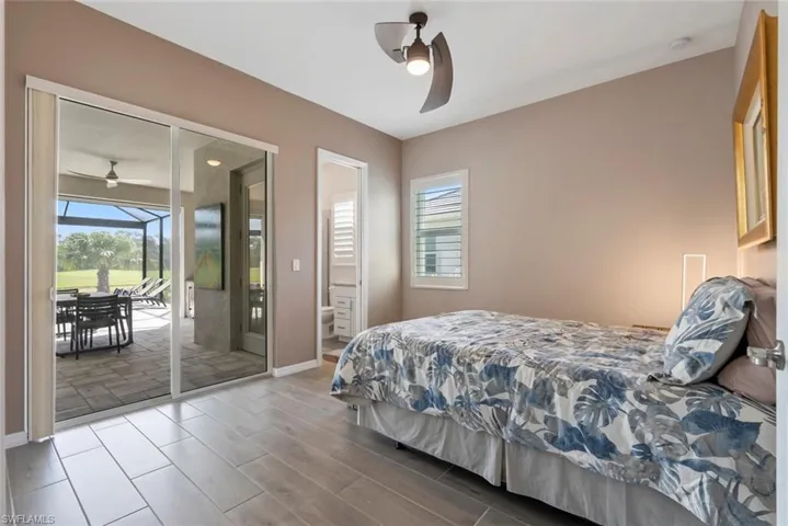 Bedroom featuring baseboards, access to outside, ensuite bathroom, and wood tiled floor