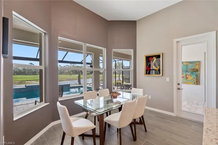 Dining space featuring a water view, baseboards, and light wood finished floors